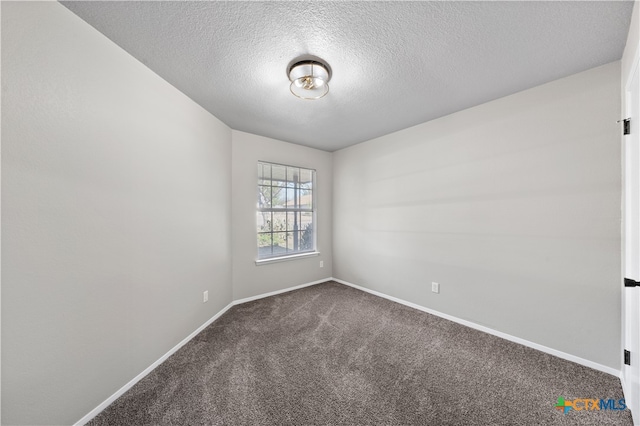 carpeted empty room with a textured ceiling