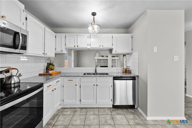 kitchen with white cabinets, light stone countertops, sink, and appliances with stainless steel finishes