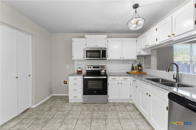 kitchen with light stone countertops, sink, pendant lighting, white cabinets, and appliances with stainless steel finishes