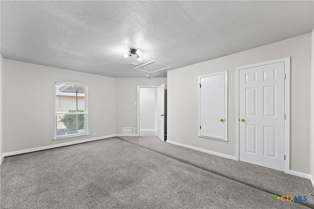 carpeted spare room featuring a textured ceiling