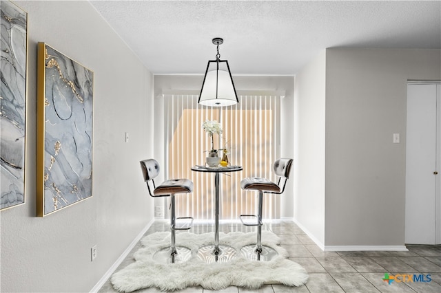 dining room featuring light tile patterned floors and a textured ceiling