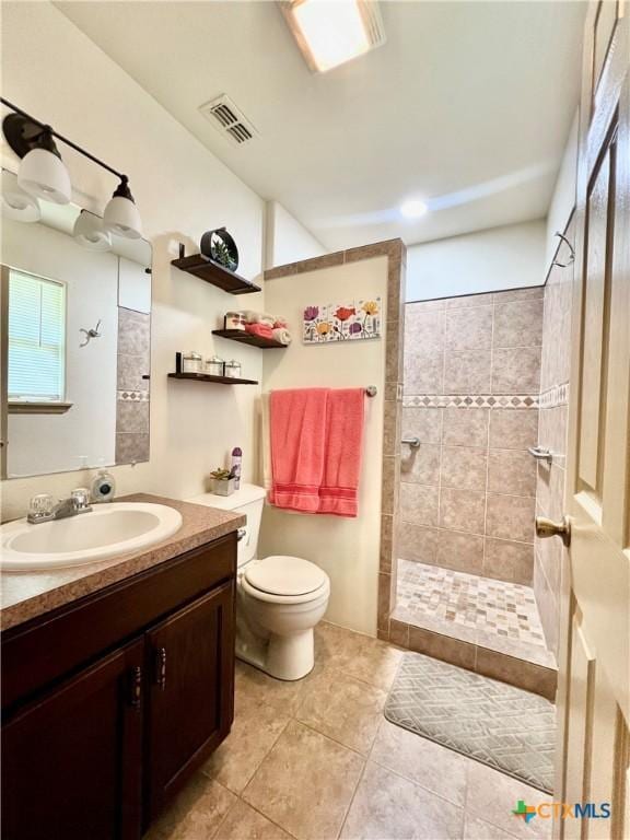 bathroom featuring walk in shower, toilet, vanity, and tile patterned flooring