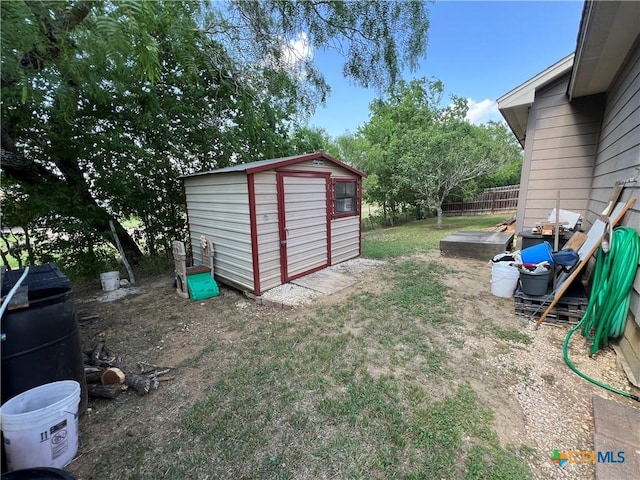 view of yard with a storage unit, an outdoor structure, and fence
