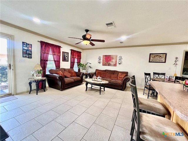 living room with light tile patterned floors, ornamental molding, and ceiling fan
