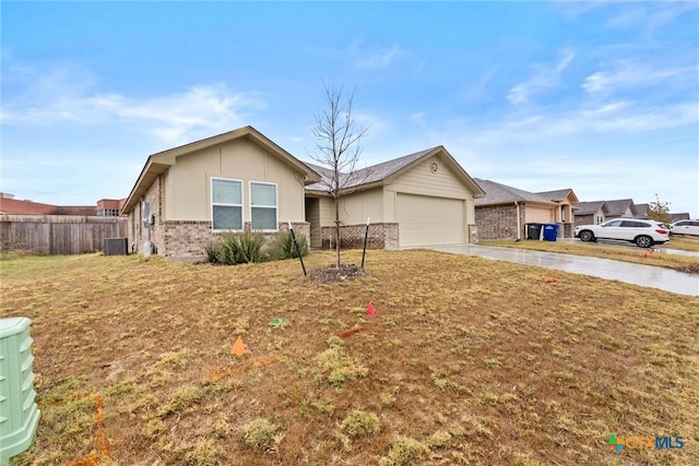 ranch-style house with a garage, a front lawn, and central AC unit