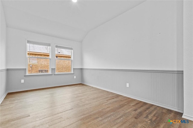 unfurnished room featuring vaulted ceiling and wood-type flooring