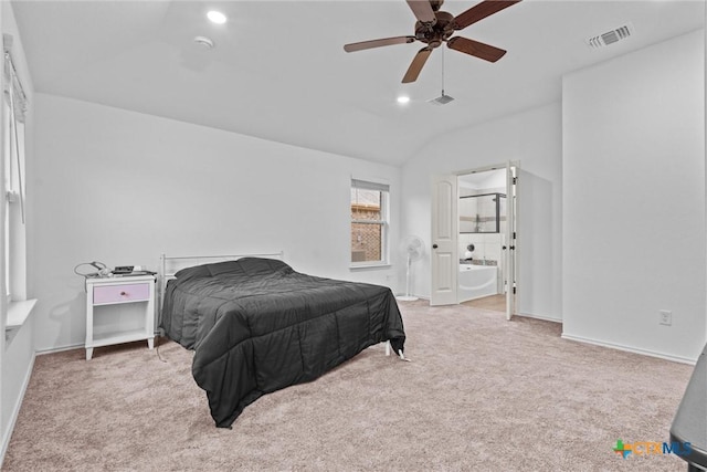 bedroom featuring ceiling fan, ensuite bath, vaulted ceiling, and light colored carpet