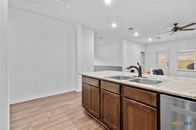 kitchen featuring ceiling fan, stainless steel dishwasher, light hardwood / wood-style flooring, light stone counters, and sink