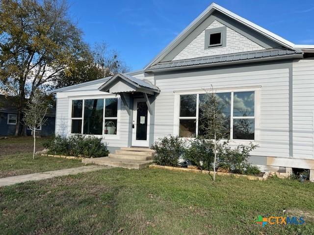 1612 Saint Peter St, Gonzales, TX 78629 - view of front of home with a front lawn and metal roof
