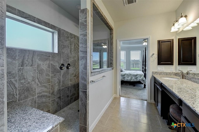 bathroom with ceiling fan, vanity, tile patterned floors, and tiled shower