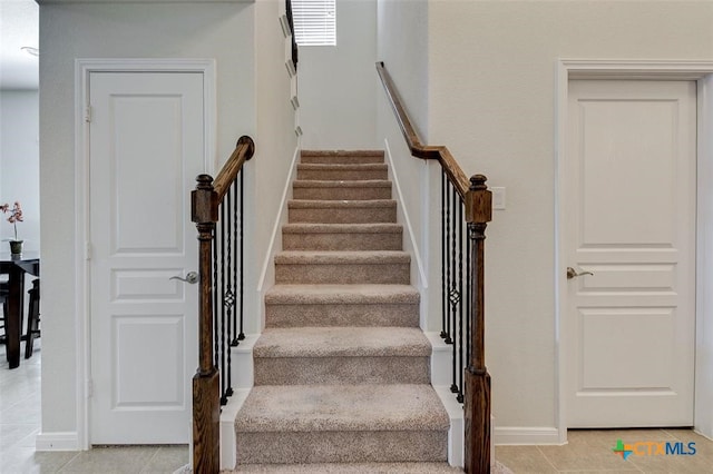 stairway with tile patterned floors