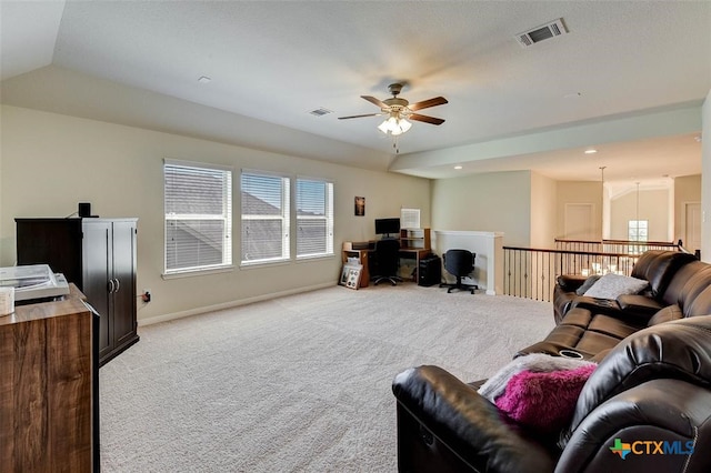 living room featuring vaulted ceiling, light colored carpet, and ceiling fan with notable chandelier