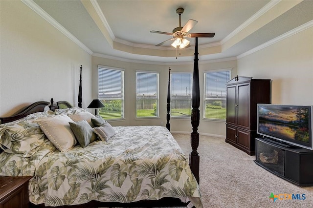 bedroom with ornamental molding, light colored carpet, ceiling fan, and a tray ceiling