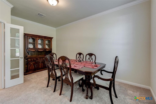 carpeted dining room with crown molding