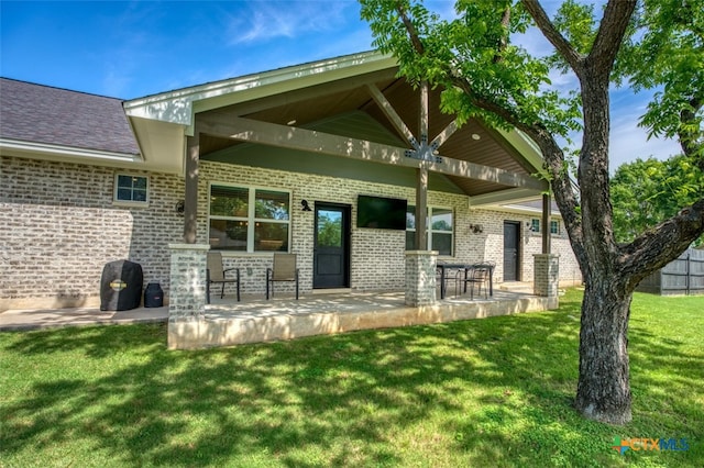 rear view of house with a yard and a patio area