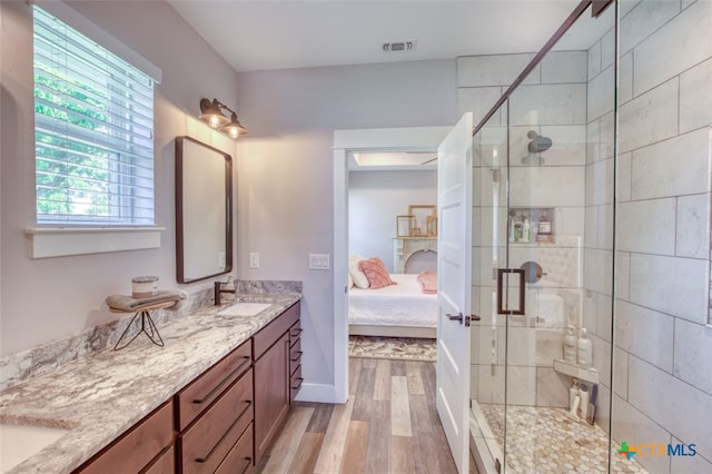 bathroom featuring wood-type flooring, vanity, a fireplace, and walk in shower