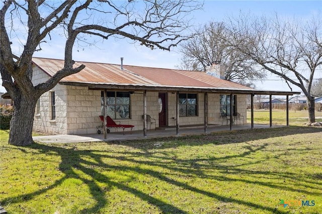 1068 Ranch Road 165, Blanco, TX 78606 - view of front of house with a front yard, metal roof, and a chimney