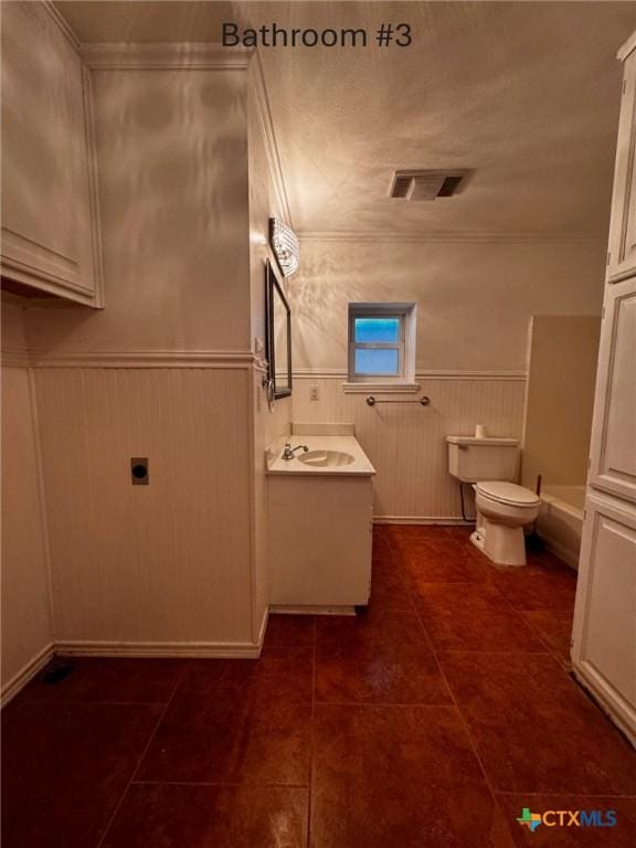 bathroom with visible vents, toilet, a wainscoted wall, tile patterned floors, and vanity