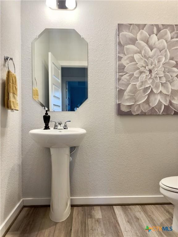 bathroom with toilet and hardwood / wood-style flooring