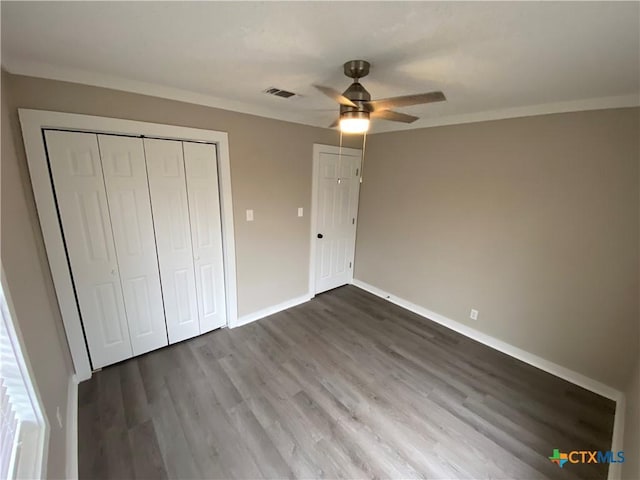 unfurnished bedroom with crown molding, wood finished floors, visible vents, and baseboards