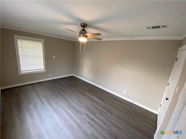 spare room featuring ornamental molding, dark wood-type flooring, visible vents, and baseboards