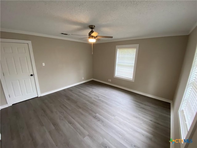 unfurnished bedroom with a textured ceiling, dark wood-style flooring, visible vents, baseboards, and crown molding