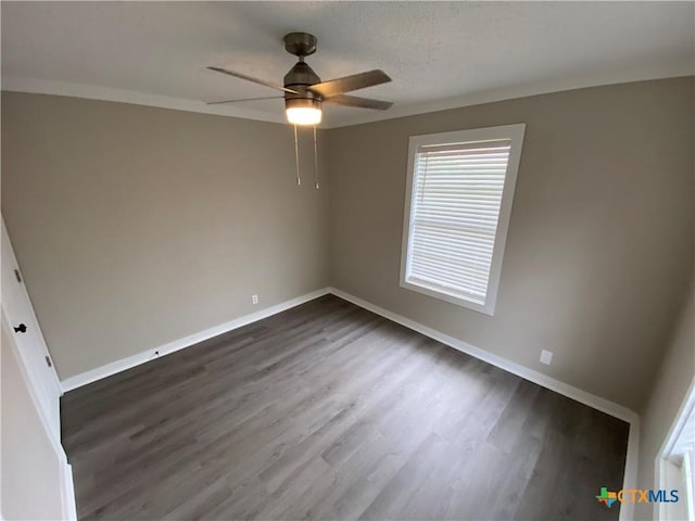 unfurnished bedroom with a textured ceiling, dark wood finished floors, a ceiling fan, and baseboards