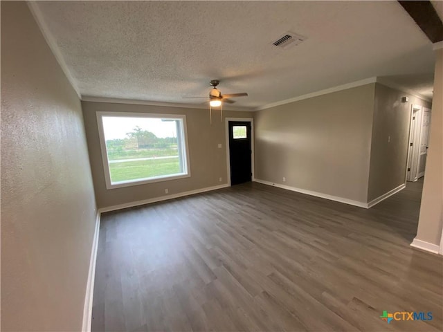 unfurnished living room with baseboards, visible vents, dark wood finished floors, and a textured ceiling