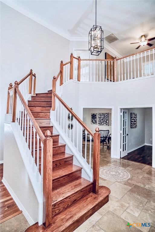2788 Morning Moon, New Braunfels, TX 78132 - stairway featuring a chandelier, baseboards, crown molding, ceiling fan, and french doors