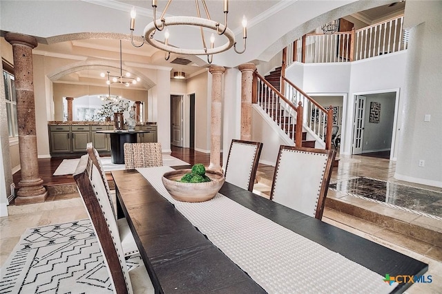 2788 Morning Moon, New Braunfels, TX 78132 - dining room with crown molding, a chandelier, ornate columns, baseboards, and arched walkways