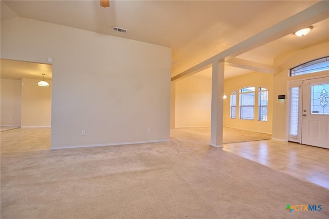 carpeted entrance foyer with plenty of natural light and lofted ceiling