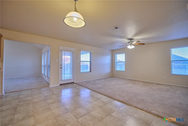 carpeted spare room featuring ceiling fan