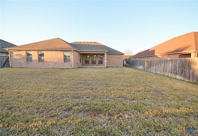 rear view of house featuring a lawn