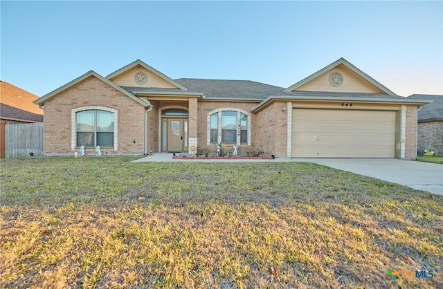 ranch-style house featuring a front lawn and a garage