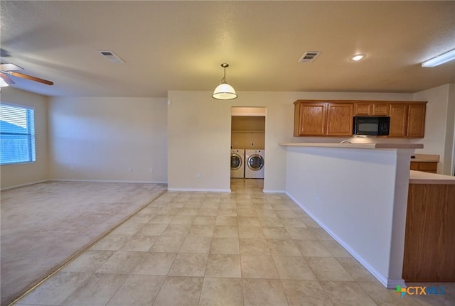 kitchen featuring washer and dryer, kitchen peninsula, hanging light fixtures, and ceiling fan