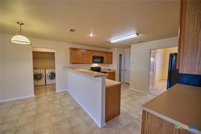 kitchen featuring black appliances, washer and dryer, a textured ceiling, decorative light fixtures, and kitchen peninsula