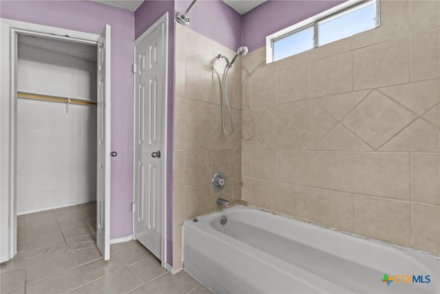 bathroom with tiled shower / bath combo and tile patterned flooring