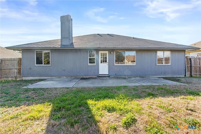 rear view of property with a yard and a patio