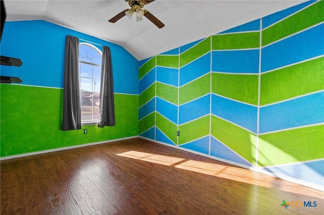 unfurnished room with lofted ceiling, ceiling fan, a textured ceiling, and hardwood / wood-style flooring