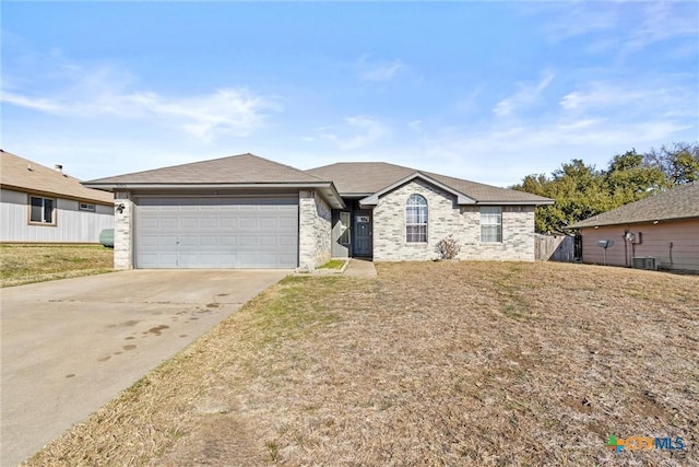 ranch-style home with a front lawn, central air condition unit, and a garage