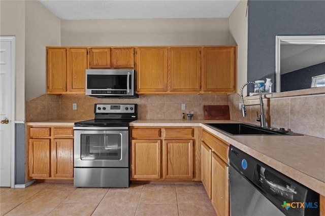 kitchen featuring backsplash, sink, stainless steel appliances, and light tile patterned flooring