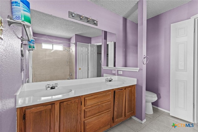 bathroom with toilet, tile patterned flooring, a textured ceiling, and vanity