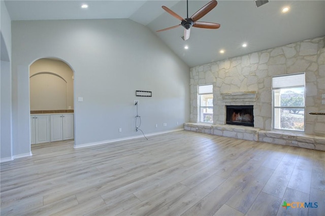 unfurnished living room with a fireplace, light hardwood / wood-style flooring, high vaulted ceiling, and plenty of natural light