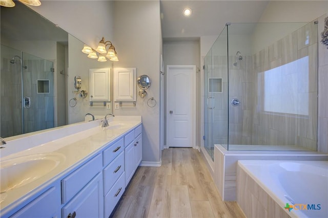 bathroom featuring vanity, separate shower and tub, and hardwood / wood-style floors