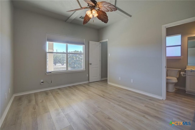 unfurnished bedroom featuring ensuite bath, light hardwood / wood-style floors, and ceiling fan