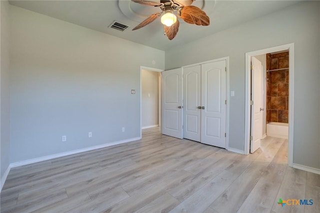 unfurnished bedroom featuring ceiling fan, ensuite bathroom, light wood-type flooring, and a closet