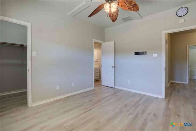 unfurnished bedroom featuring ceiling fan, a spacious closet, light hardwood / wood-style floors, and a closet