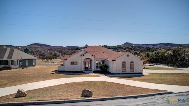 view of front of property with a mountain view and a front lawn