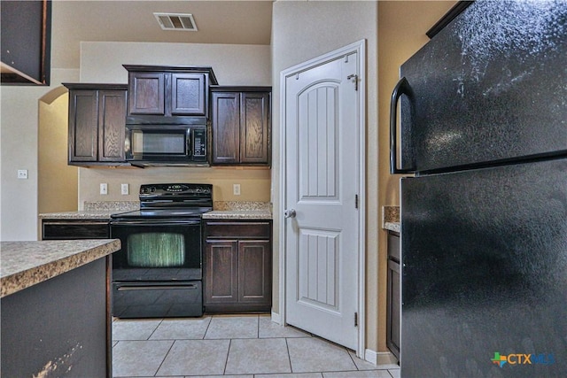 kitchen with light tile patterned floors, dark brown cabinets, and black appliances