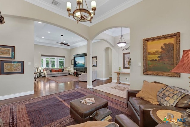 living room with visible vents, arched walkways, wood finished floors, and ornamental molding